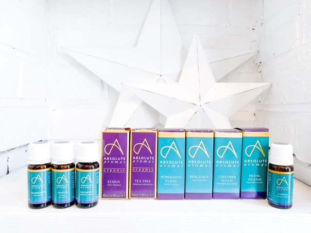 A row of essential oil blends for men, sitting on a white shelf.